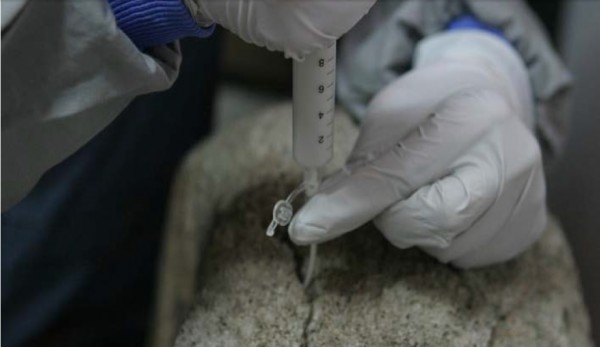 국립문화재연구소 연구진은 불국사 다보탑 복원 과정에서 갈라진 틈에 실리콘 관을 꽂고 주사기로 에틸실리케이트와 무기질 성분이 포함된 용액을 채워 넣었다. - 문화재청 제공